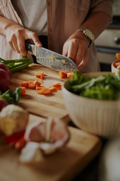 A resident chops fresh vegetables in her kitchen at The Howard, Glendale, California