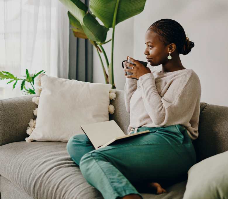 A woman in her new apartment enjoying a cup of coffee at Flatiron District at Austin Ranch in The Colony, Texas