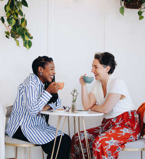 Two residents sharing some coffee together at The Margaret at Riverfront in Dallas, Texas