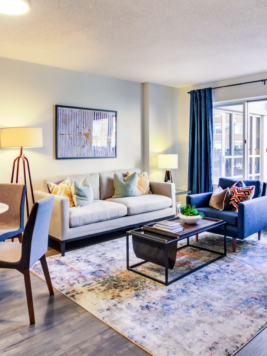 Naturally lit living room with large bay windows in a model home's living area at Sofi at 50 Forest in Stamford, Connecticut