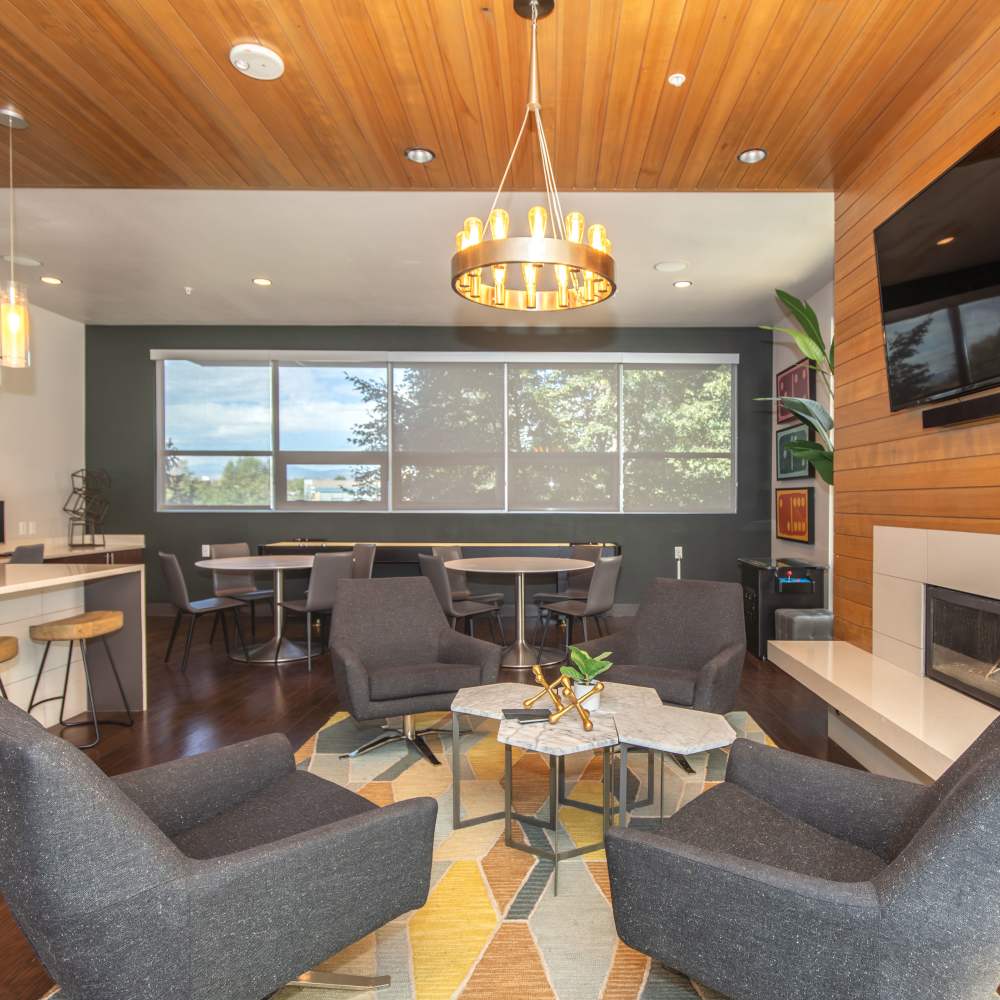 Community clubhouse with chairs, tables and large window at Park Place Olde Town Apartments in Arvada, Colorado