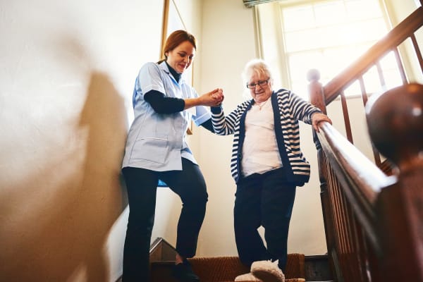 A caregiver assisting a resident down the stairs at Harmony Senior Services in Charleston, South Carolina
