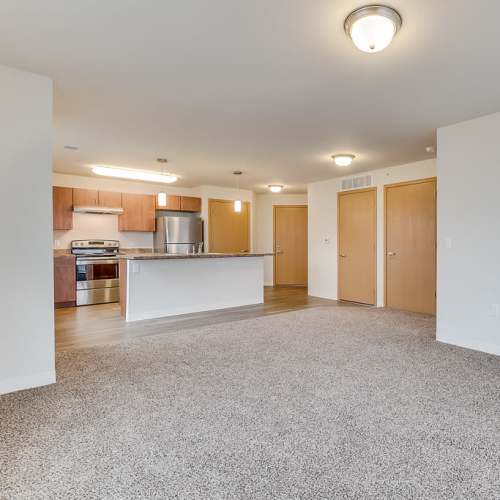 Apartment living room with kitchen at Fox Crossing Apartments in Burlington, Wisconsin