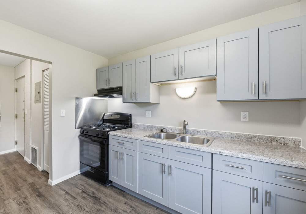 A modern kitchen featuring stainless steel appliances and a kitchen sink at Pin Oak Manor Apartments in Mishawaka, Indiana