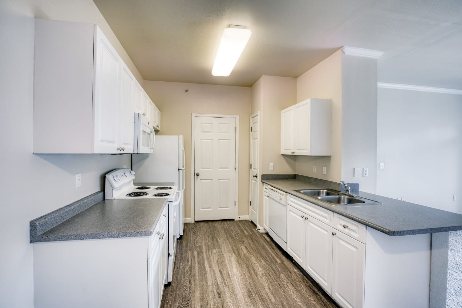 Spacious kitchen with dark counters and white cabinets at Reserve at South Creek in Englewood, Colorado