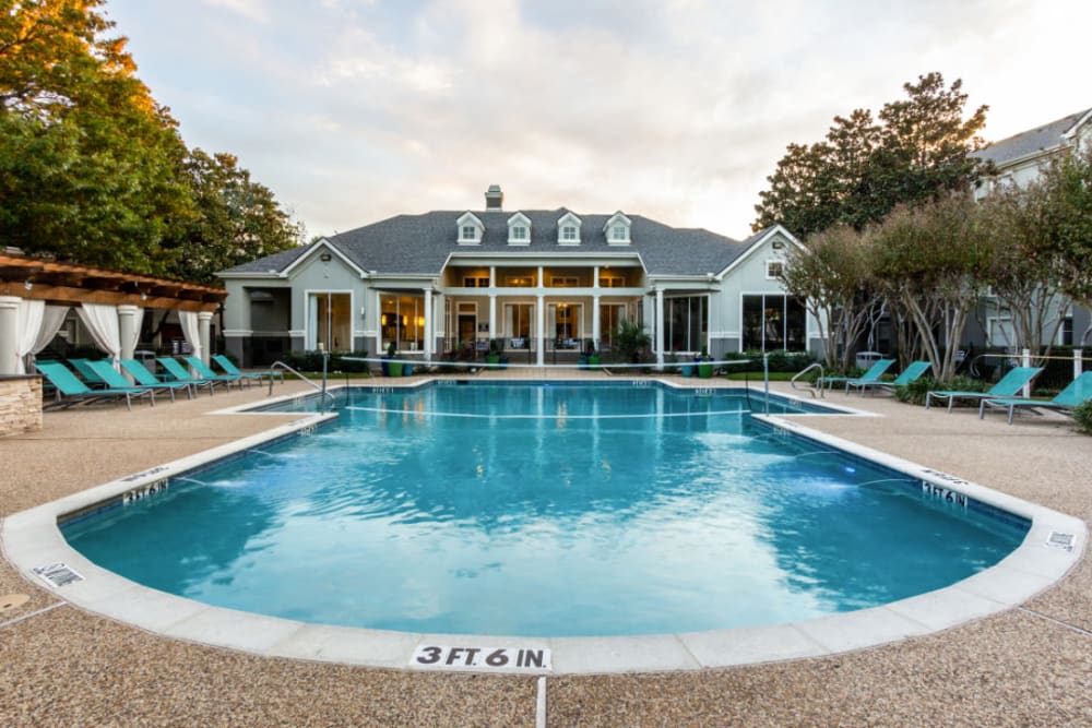 Pool with volleyball net and clubhouse at Marquis at Stonegate in Fort Worth, Texas