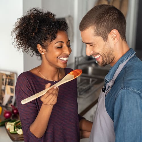 A smiling couple makes dinner at The Hardison in Salt Lake City, Utah