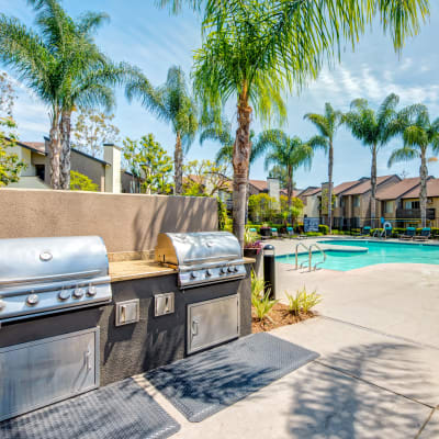 Barbecue area with gas grills near the swimming pool at Sofi Laguna Hills in Laguna Hills, California