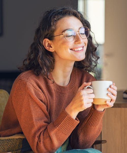 Resident relaxing in her apartment with a cup of tea at Arbor Brook in Murfreesboro, Tennessee