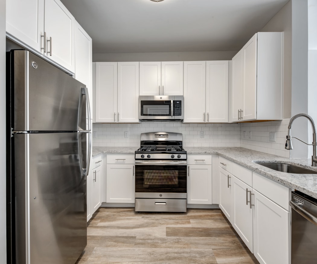 View of modern kitchen over breakfast bar in model home at Prynne Hills in Canton, MA