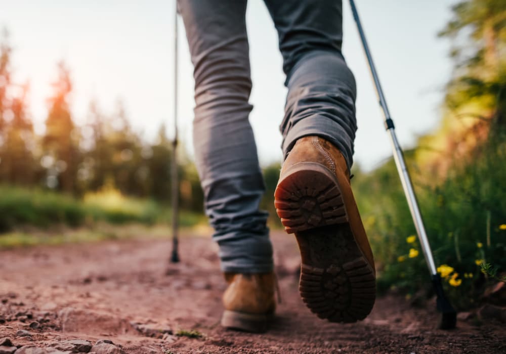 Person walking down a dirt road with walking sticks near The Luxe at Cedar Hill in Cedar Hill, Texas