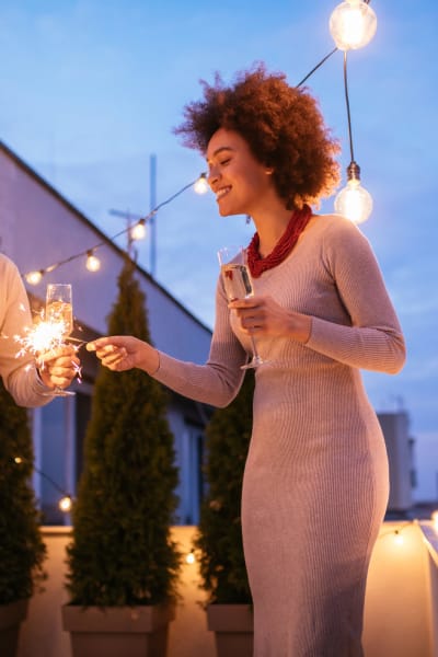 Resident lighting a sparkler at dusk on her private balcony at Solera at City Centre in Palm Beach Gardens, Florida