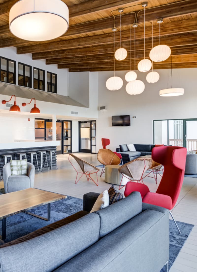 Community clubhouse with lounge area, fireplace, and kitchen area at Ashford Belmar in Lakewood, Colorado