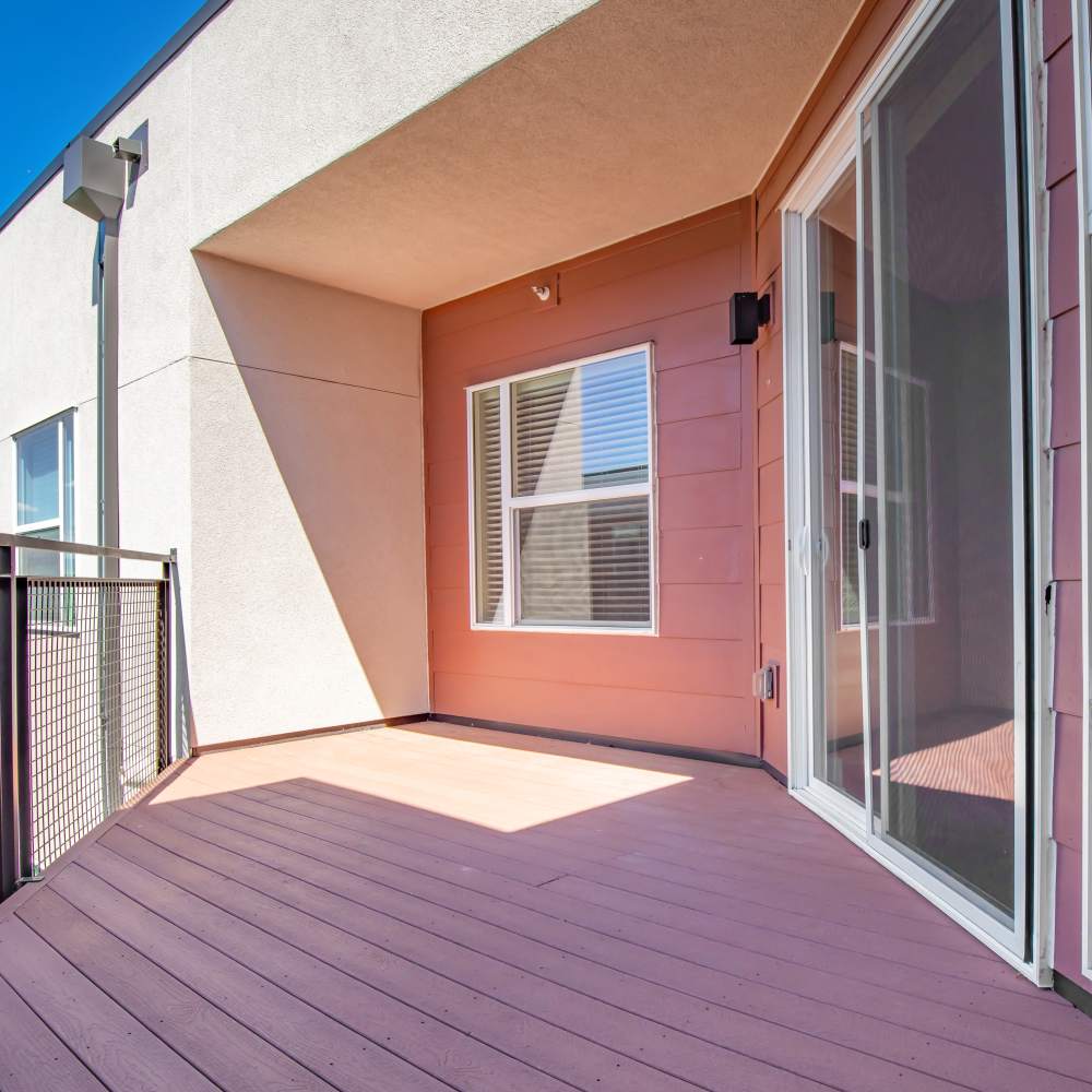 Private balcony with galss door and wood-style flooring at Park Place Olde Town Apartments in Arvada, Colorado