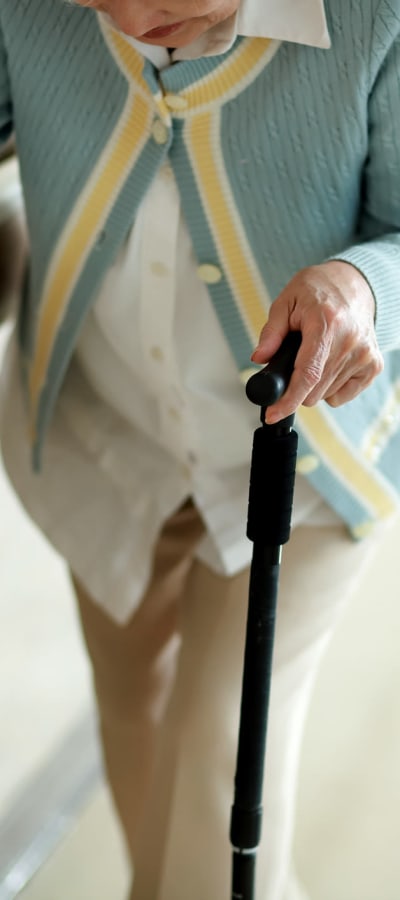 Resident walking with cane at a WISH community