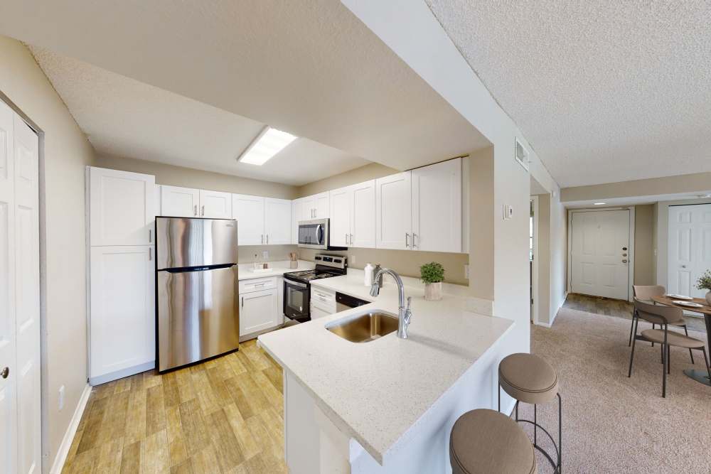 Open kitchen with white cabinets and breakfast bar at Cypress Run in Orlando, Florida
