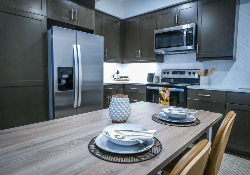 Kitchen with stainless-steel appliances and wooden flooring at The Courtyards Pacific Village in San Diego, California