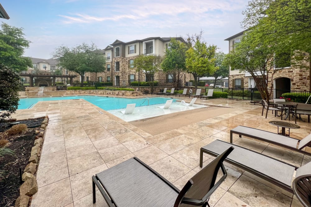 Beautiful resort-style swimming pool with lounge chairs and a barbecue area at Broadstone Grand Avenue in Pflugerville, Texas