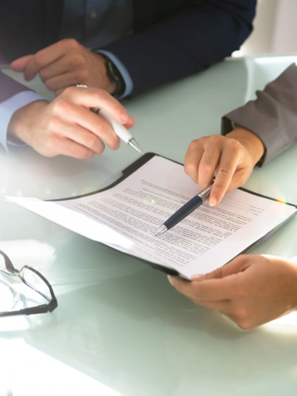 Two employees reviewing a document at NextGen Properties in Costa Mesa, California