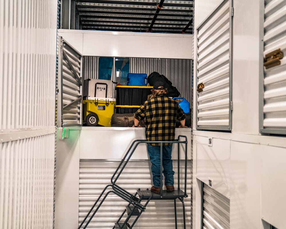 Man adds some camping gear to his storage locker after a great weekend in the outdoors.