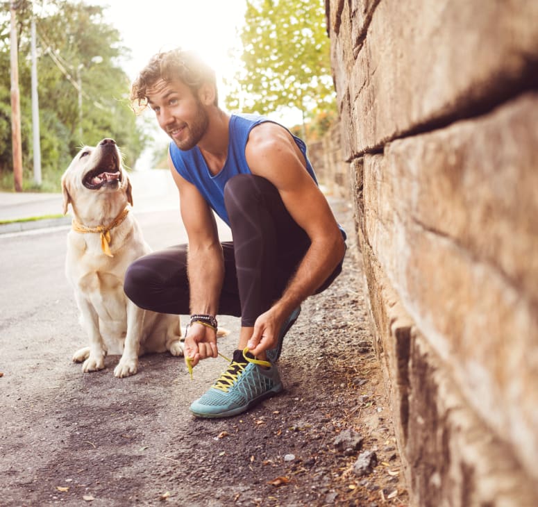 Man tying show with Yellow Lab by his side at Vancouver, Washington