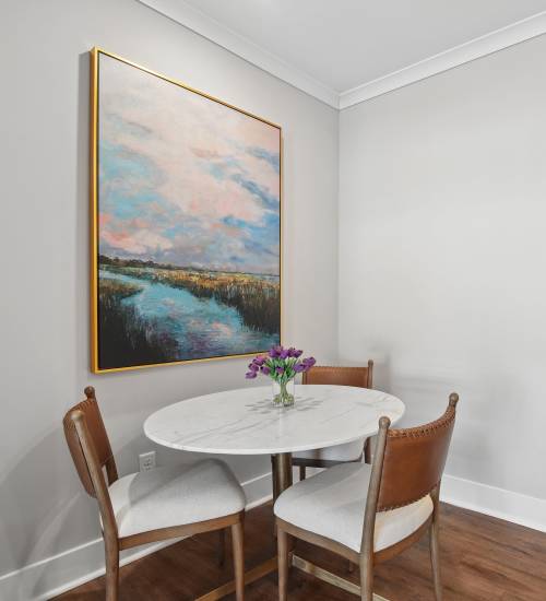 Cozy dining area with a round marble table and four chairs, colorful artwork on the wall at Everett at Port Wentworth in Port Wentworth, Georgia