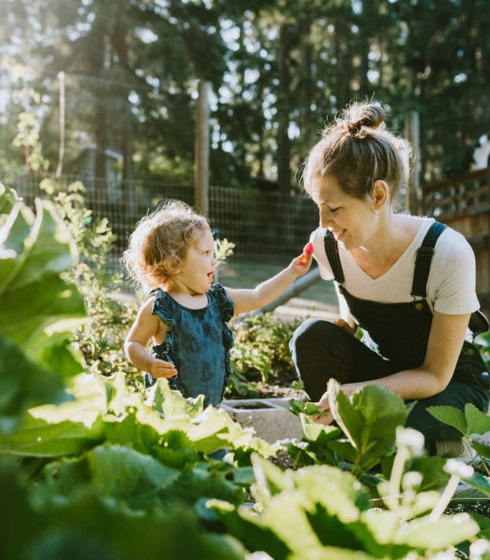 Resident and their child doing some gardening outdoors at Chisholm Pointe in Oklahoma City, Oklahoma