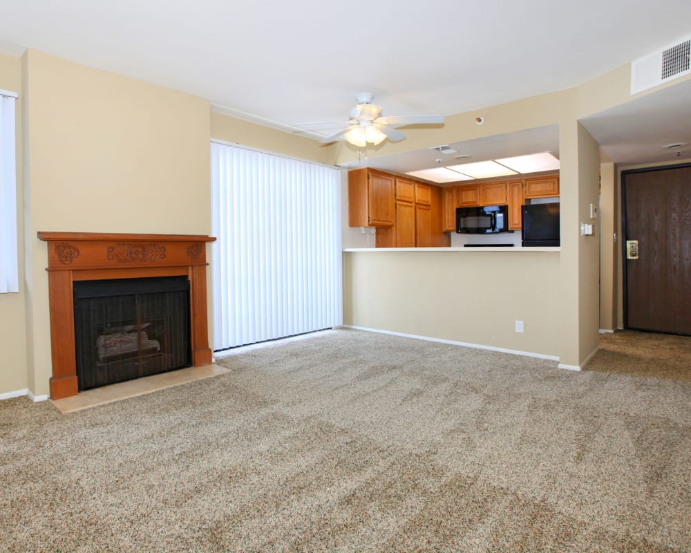 Model living room and kitchen with fireplace at Savoy West Apartments in Los Angeles, California