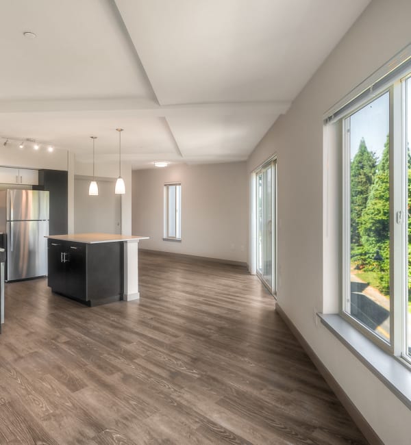 Kitchen with island, hardwood flooring throughout, and a large open living space at Tria Apartments in Newcastle,