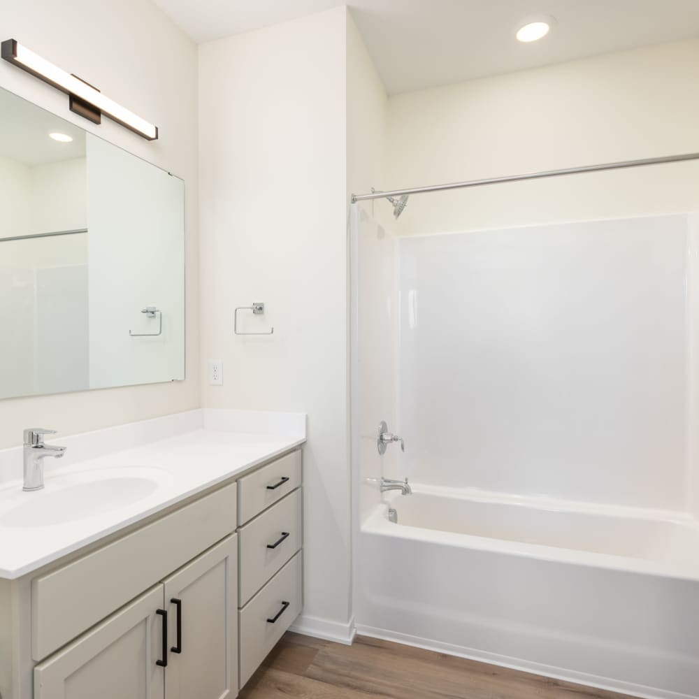 Well-lit bathroom with bathtub at The Uptown Apartments in Waconia, Minnesota