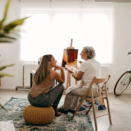 Resident painting with a caretaker at Oxford Springs Tulsa Memory Care in Tulsa, Oklahoma