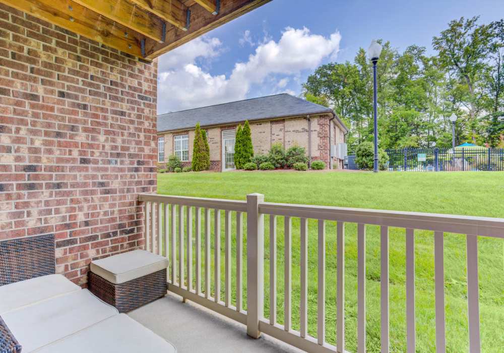 Patio with comfortable furniture and view of green landscape at Innisbrook Village in Greensboro, North Carolina