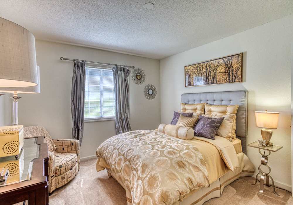 Comfortable and well-lit bedroom with window at Treybrooke Village in Greensboro, North Carolina