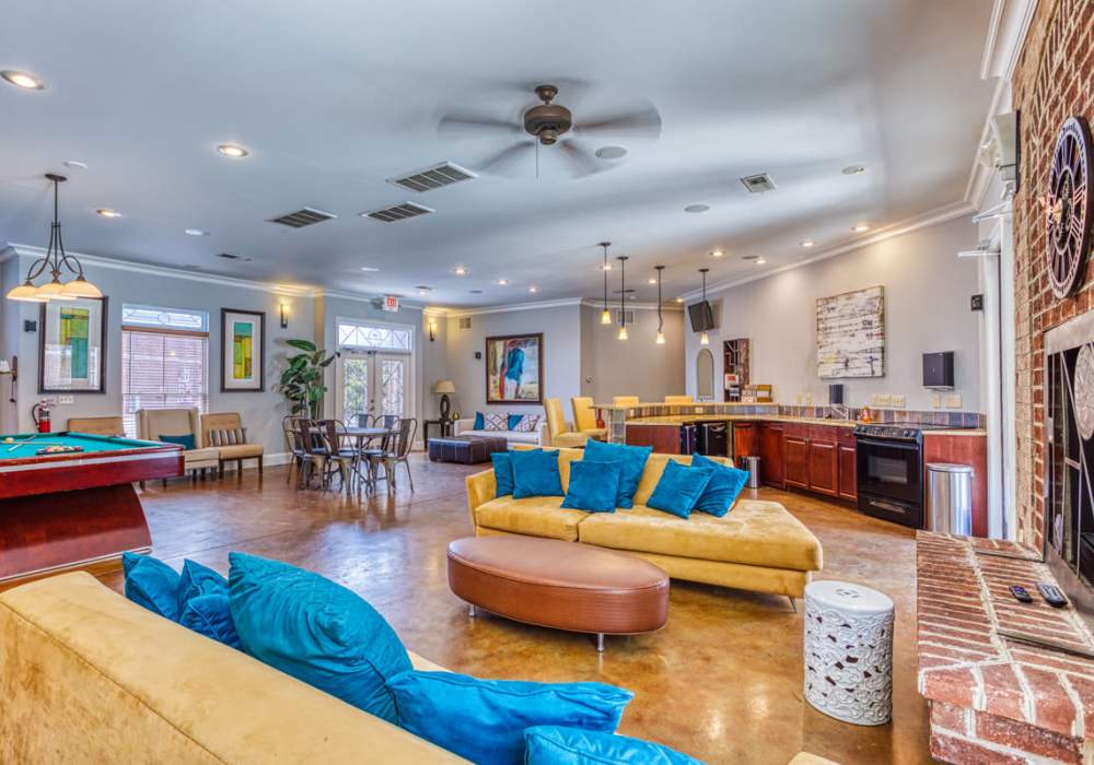 Community game room with kitchen, fireplace, couches, and pool table at CityView Apartments in Greensboro, North Carolina