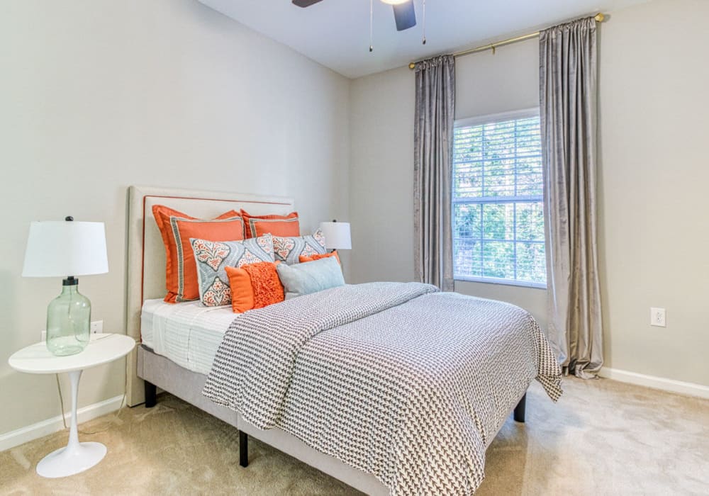 Bedroom with carpeting, full bed, bedside table and lamp, and a great view through the window at Greymont Village in Asheville, North Carolina