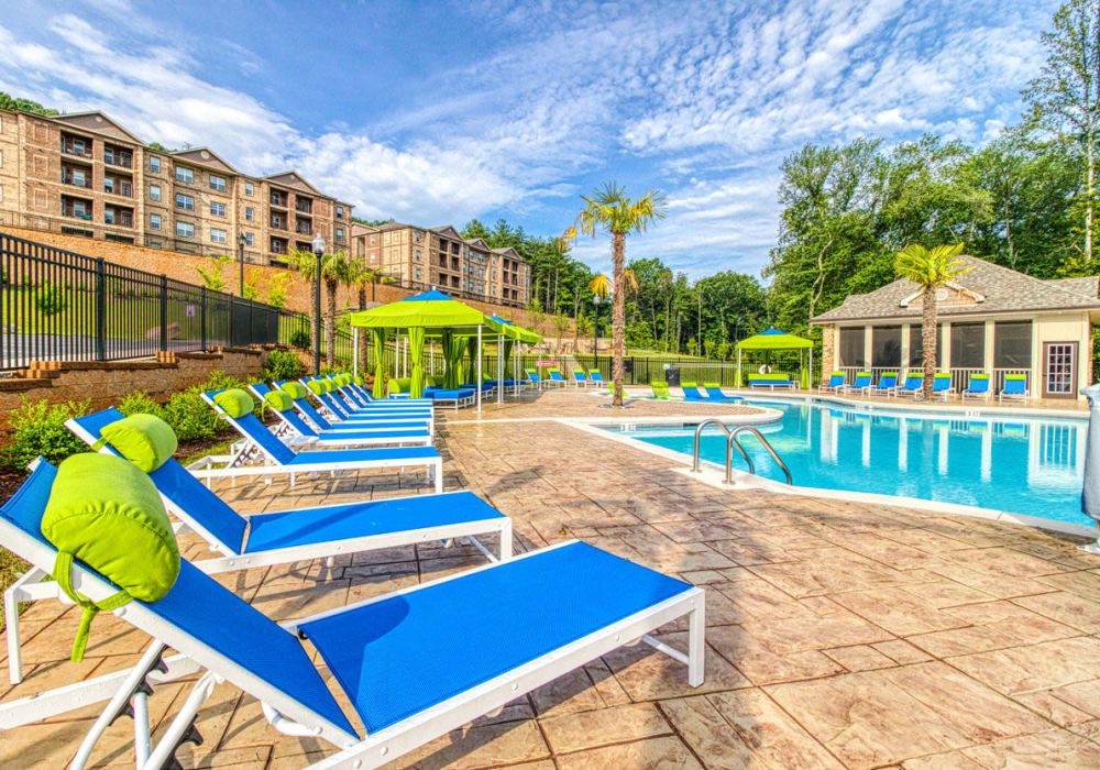 Pool area with chaise lounge chairs on the tanning sundeck and clubhouse at Greymont Village in Asheville, North Carolina