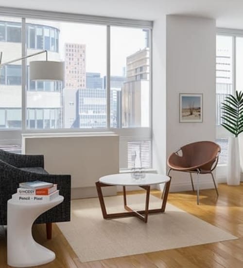 A living room with wood-style flooring with floor-to-ceiling windows at The Metropolis in New York, New York
