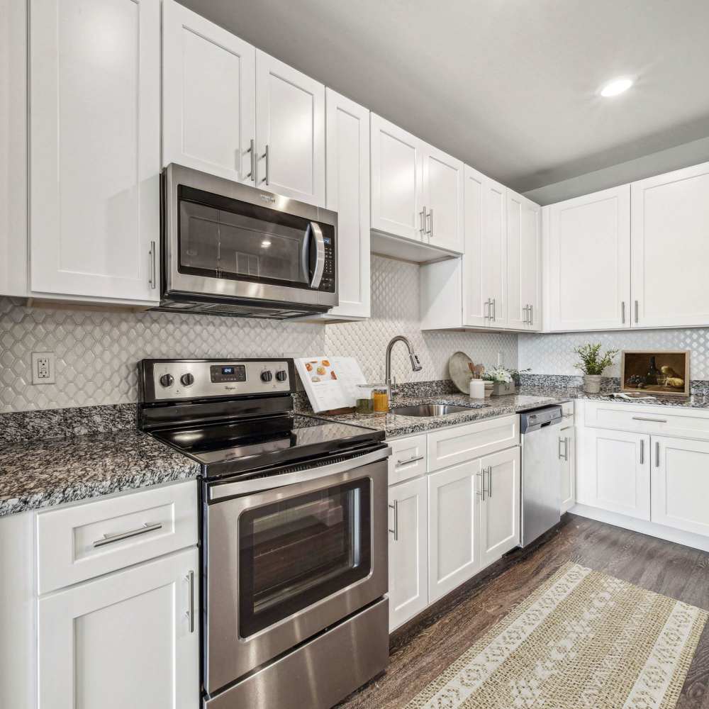 White cabinetry and stainless-steel appliances in the modern kitchen at Chroma in Saint Louis, Missouri