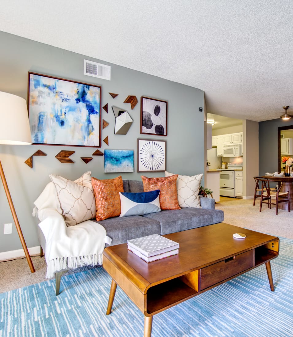 Plush carpeting and an accent wall in the well-furnished living space of a model home at Waterstone Fremont in Fremont, California