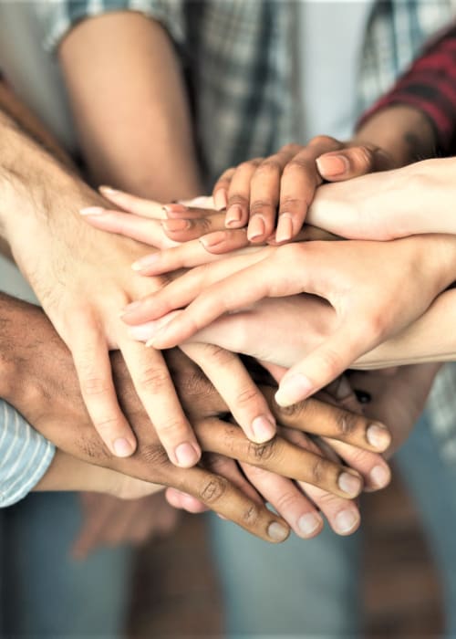 Group of hands in together at The Pillars of Grand Rapids in Grand Rapids, Minnesota