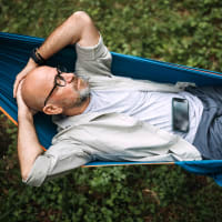 A man relaxing in a hammock outside at The Lively Indigo Run in Ladson, South Carolina