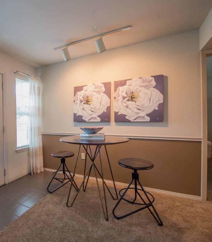 Elegant bar stool seating area with paintings at Crown Chase Apartments in Wichita, Kansas