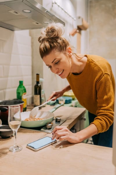 A resident prepares a meal while checking her phone at Los Feliz Village, Los Angeles, California