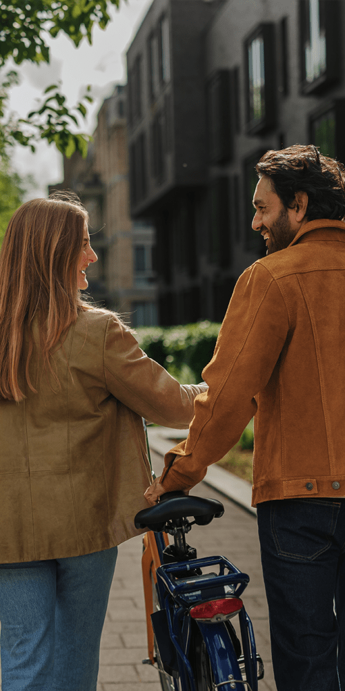 Couple walking with a bicycle in a modern neighborhood at Residences at 111 Lyon in Grand Rapids, Michigan