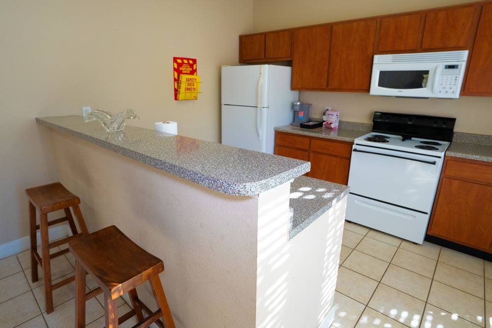 Community kitchen with modern appliances and breakfast bar at Millpoint Townhomes in Henderson, Texas