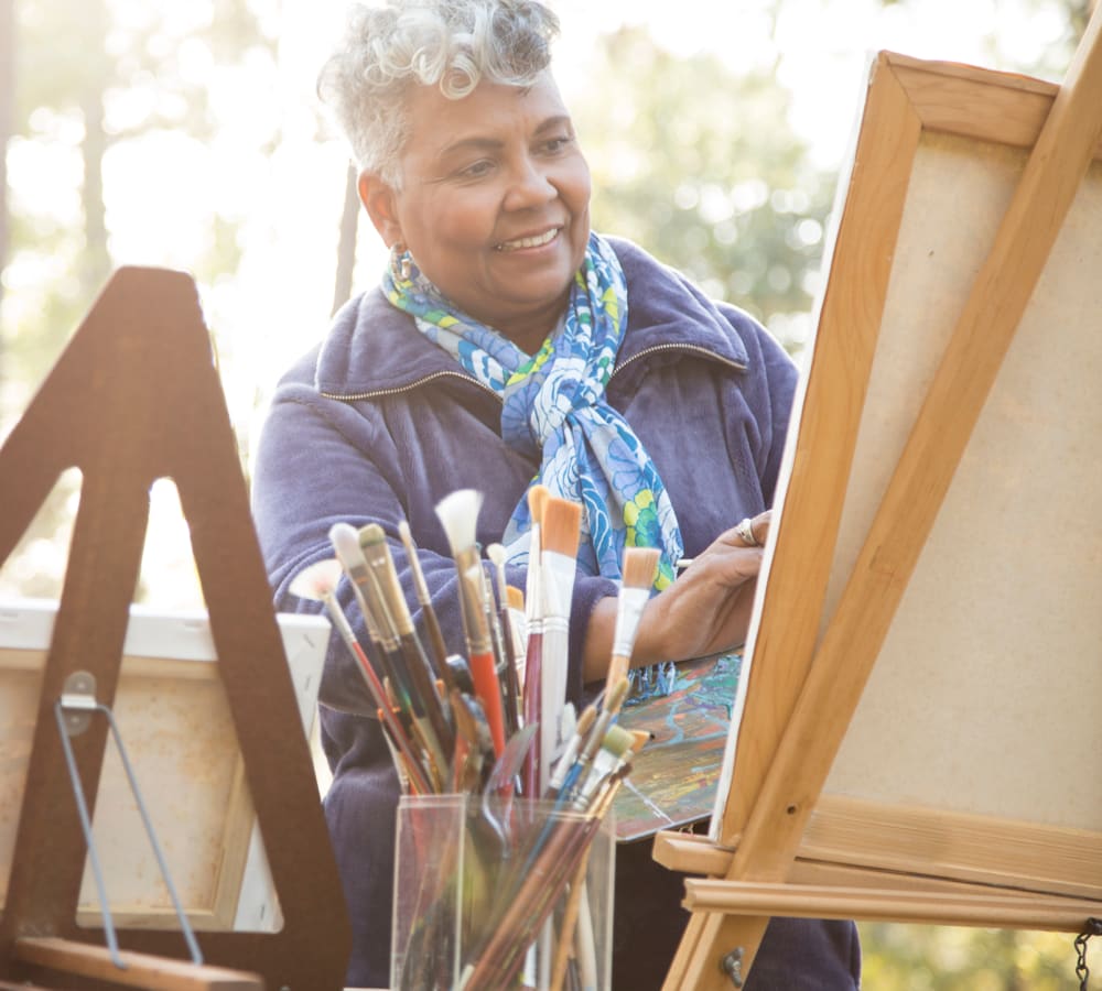 Resident painting a picture on an easel at Bishop Place Senior Living in Pullman, Washington