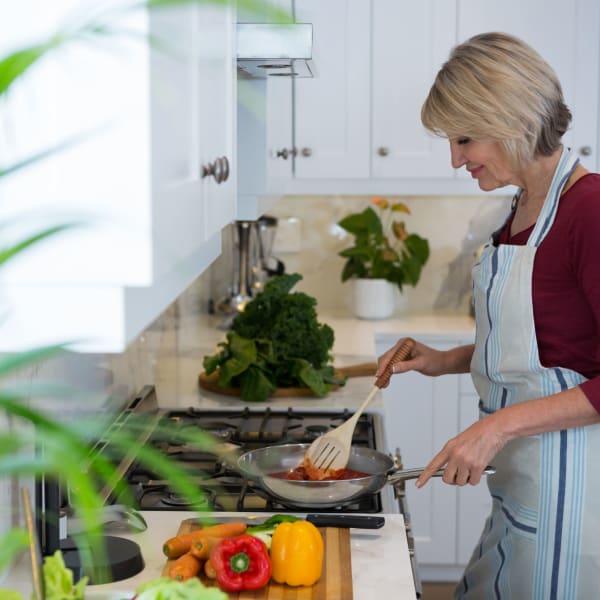 A resident prepares a meal in her kitchen at Alate Old Town, Alexandria, Virginia