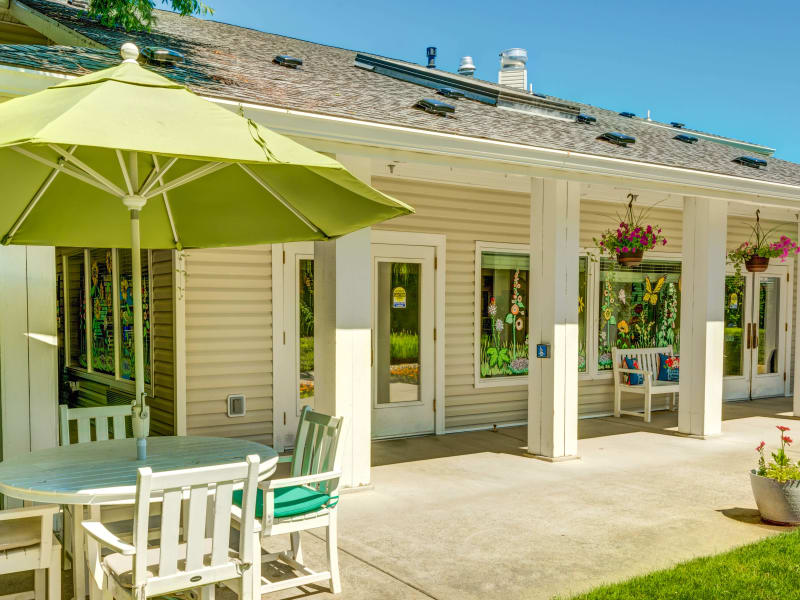 Inviting veranda with outdoor seating and hanging flower baskets at The Suites Assisted Living and Memory Care in Grants Pass, Oregon. 