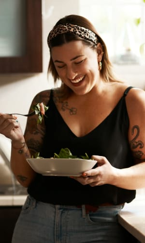 Resident enjoying a meal in her kitchen at Sierra Vista Apartments in Midlothian, Texas