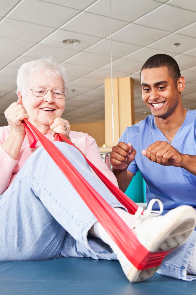 Resident working with an exercise band with help from a caretaker at Ingleside Communities in Mount Horeb, Wisconsin